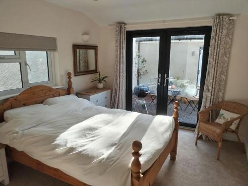 1 dormitorio con 1 cama grande y balcón en New spacious and sunny annexe with Underfloor heating throughout, en Culmstock