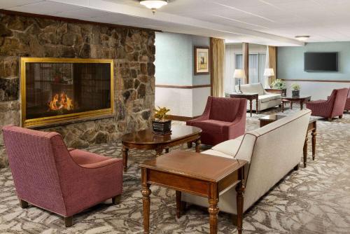 a lobby with chairs and a fireplace in a hotel at Ramada Plaza by Wyndham Portland in Portland