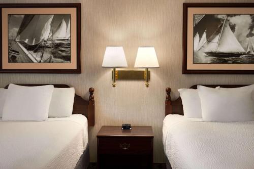 a hotel room with two beds and two lamps at Ramada Plaza by Wyndham Portland in Portland