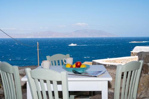 a table and chairs with a bowl of fruit on it at Marialena's studio in Agios Ioannis Mykonos