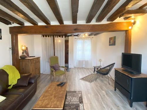 un salon avec un canapé et une télévision dans l'établissement L'Ecuyère-Maison de Ville-Secteur cathédrale-Parking privé gratuit, à Chartres