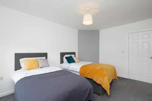 duas camas sentadas uma ao lado da outra num quarto em 2 Bed Littleover Derby House (long stays / parking) em Derby