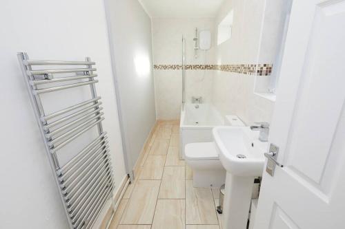 uma casa de banho branca com um lavatório e um WC em 2 Bed Littleover Derby House (long stays / parking) em Derby