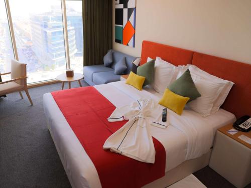 Novotel Suites Riyadh Centre في الرياض: غرفة فندق فيها سرير عليها قوس