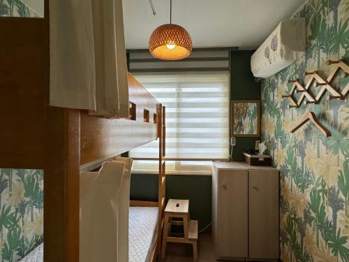 Habitación pequeña con escalera y escritorio. en Greenday Guesthouse en Jeju