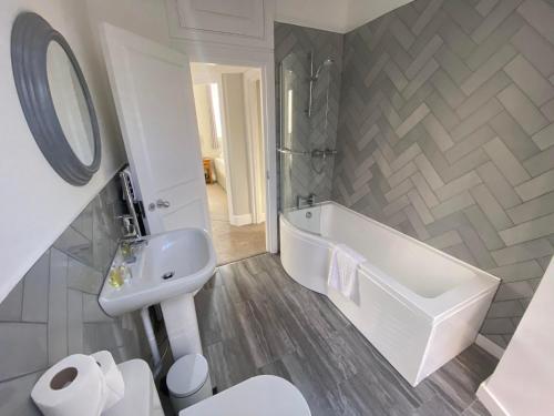 a white bathroom with a tub and a sink at Crowcombe Court in Crowcombe