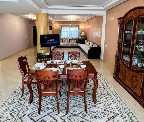 y sala de estar con mesa de comedor y sillas. en Belle villa spacieuse et cosy, en Marrakech