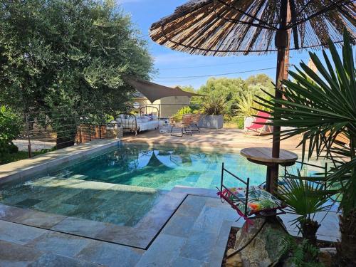 piscina con ombrellone e tavolo di Casa Chioso- Petit coin de paradis à Sisco a Sisco