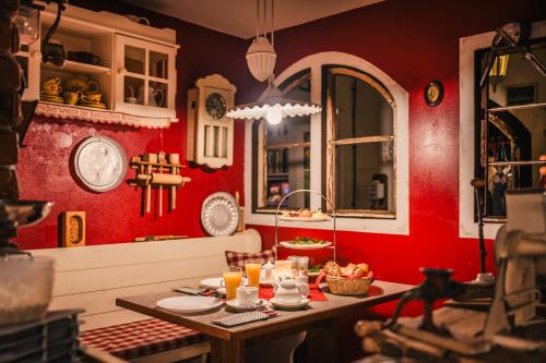 a kitchen with red walls and a table with food at Oma's Küche & Quartier in Binz