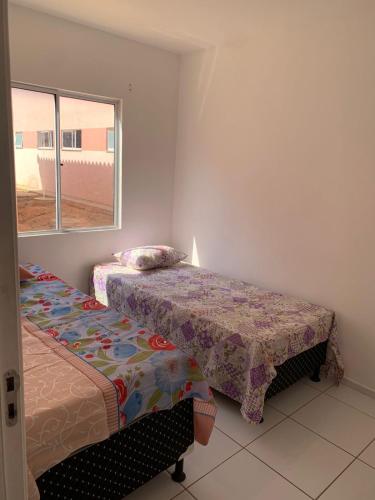 1 dormitorio con 2 camas y ventana en Aconchego, en Petrolina