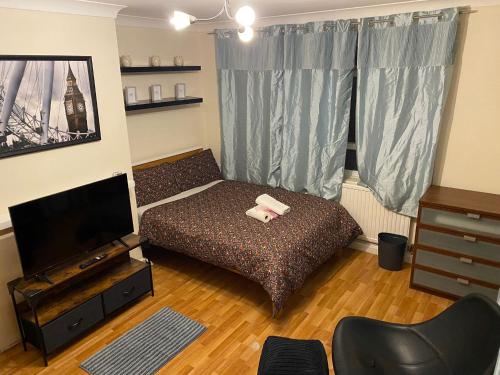 Habitación pequeña con cama y TV. en Huge and affordable 3 bedroom flat in Hammersmith for 6 people with breakfast en Londres