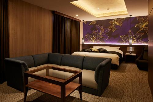 a hotel room with a couch and a bed at ホテル 尼乃美楽 尼崎 in Amagasaki