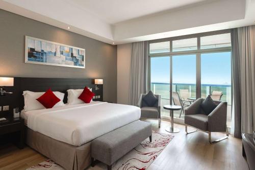 Ramada by Wyndham Dubai Barsha Heights في دبي: غرفة فندقية بسرير ونافذة كبيرة