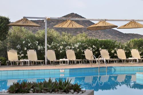 a row of chairs and umbrellas next to a swimming pool at Elounda Krini Hotel in Elounda