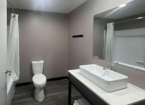 een badkamer met een wastafel, een toilet en een spiegel bij Studio 6 Oklahoma City, OK South in Oklahoma City
