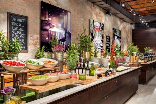 a buffet line with vegetables and wine bottles at Vienna House by Wyndham Andel's Lodz in Łódź