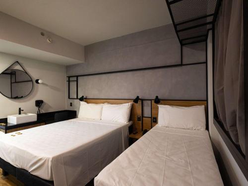 バラ・ド・ガルサスにあるibis Barra do Garcasのベッドルーム1室(ベッド2台、鏡付)