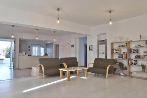a living room with two chairs and a coffee table at Elounda Krini Hotel in Elounda