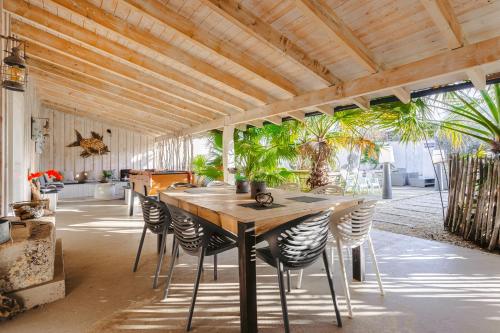 une salle à manger avec une table et des chaises en bois dans l'établissement Villa la forge expérience bien-être, à Nuaillé-dʼAunis