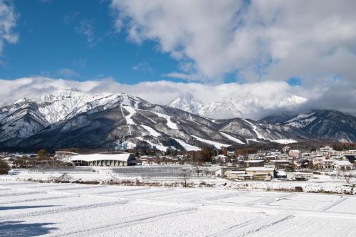 a town in front of a snowy mountain range at FLYING HOUSE in Chikuni