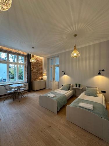 a large bedroom with two beds and a table at Kamienica Ogrodowa Rooms in Sopot