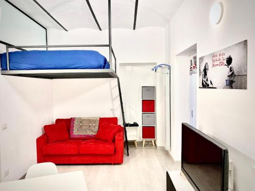 - un salon avec un canapé rouge et des lits superposés dans l'établissement Irene House Malpensa Milan Lakes, à Busto Arsizio