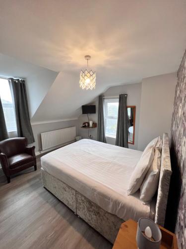 - une chambre avec un grand lit et un lustre dans l'établissement Fiddlestone Bar and B&B, à Belleek