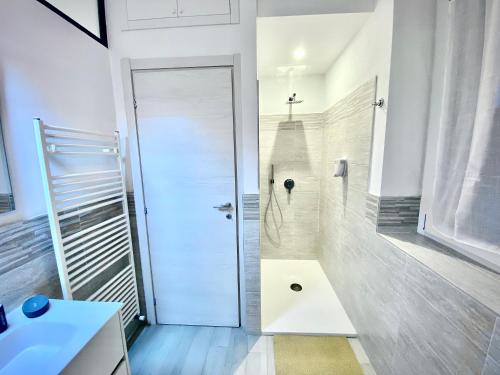 une salle de bain avec douche et porte blanche dans l'établissement Irene House Malpensa Milan Lakes, à Busto Arsizio