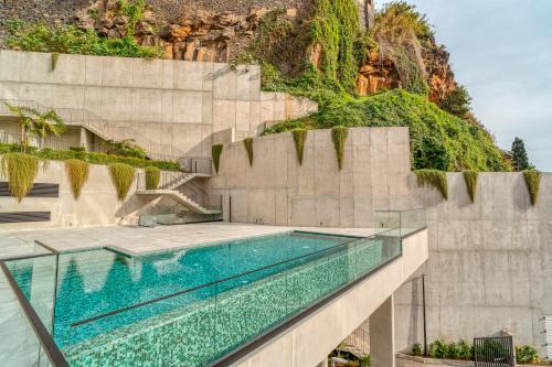 a swimming pool with a mountain in the background at Vista Verde Apartment by Amazing Madeira in Funchal