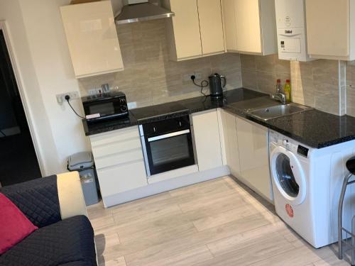 a kitchen with a washing machine and a washer at R J Apartment in London