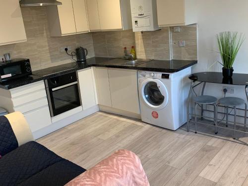 a kitchen with a washer and a washing machine at R J Apartment in London