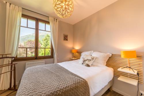 1 dormitorio con cama y ventana grande en La Villa des Grillons, outstanding lake view and private garden - LLA Selections by Location Lac Annecy, en Veyrier-du-Lac