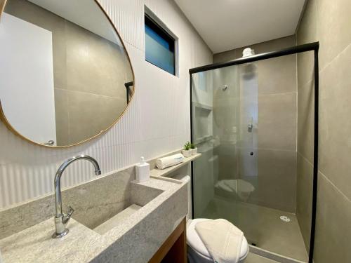 a bathroom with a shower and a sink and a mirror at Green Porto 103 Flat novíssimo no centro de Porto in Porto De Galinhas
