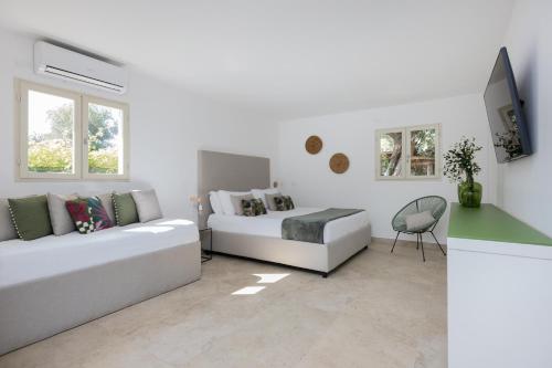a white living room with a couch and a tv at Sopramare Resort in Piano di Sorrento