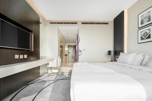 Habitación de hotel con cama grande y TV de pantalla plana. en Walaa Homes Elite Studio at Damac Esclusiva Tower Riyadh-401, en Riad