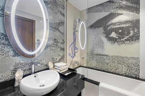 y baño con lavabo y espejo. en Walaa Homes Elite Studio at Damac Esclusiva Tower Riyadh-401, en Riad