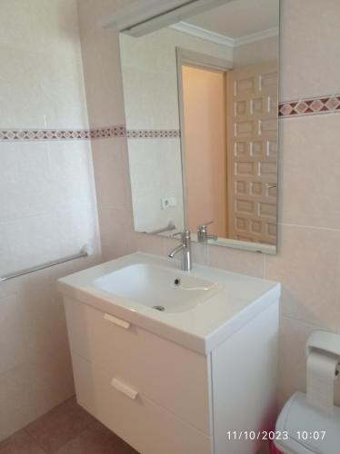 a bathroom with a white sink and a mirror at Apartamento Illa Blanca in Es Pujols