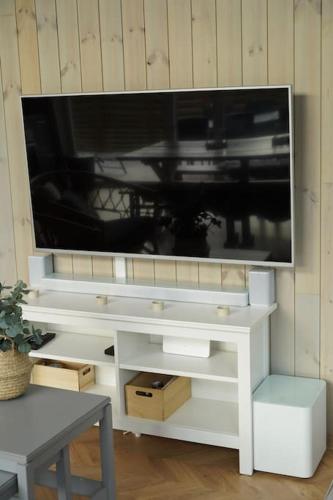 a tv sitting on top of a white entertainment center at Tretoppen - Ny moderne hytte, Unike Finnskogen in Torsby