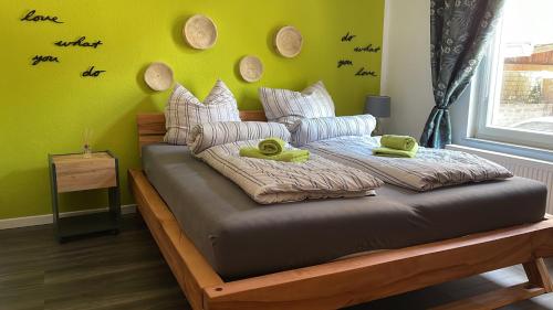 a bed in a room with a green wall at Stadthaus Artur - Apartment Valencia in Remscheid