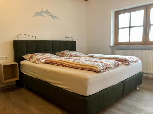 a bed with a green headboard in a bedroom at Schelterhof in Wunsiedel