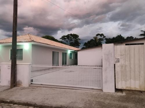 einen weißen Zaun vor einem weißen Haus in der Unterkunft Hotel Morro do campo in Antônio Carlos