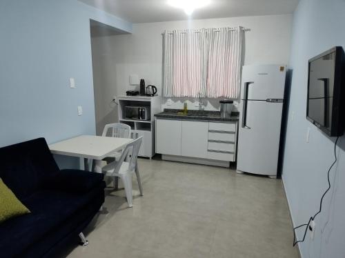 eine Küche mit einem Sofa, einem Tisch und einem Kühlschrank in der Unterkunft Hotel Morro do campo in Antônio Carlos