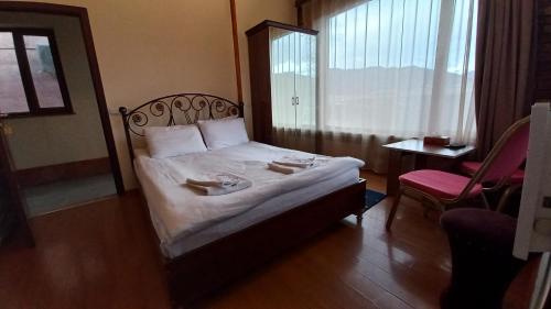 a hotel room with a bed with two towels on it at Kefilyan Family Hotel in Haghpat