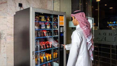 a man is looking inside of a refrigerator at لـحظــات حــراء in Jeddah
