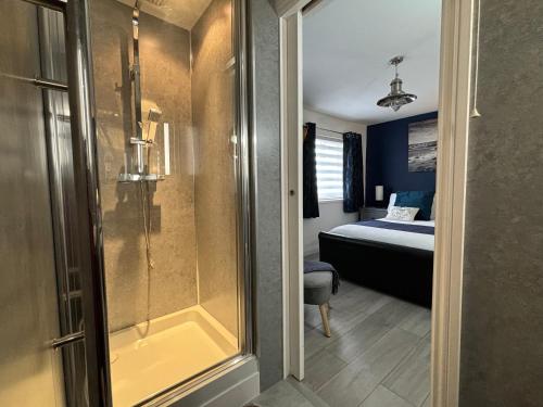 a bathroom with a shower and a bed in a room at Craster Crew House in Craster