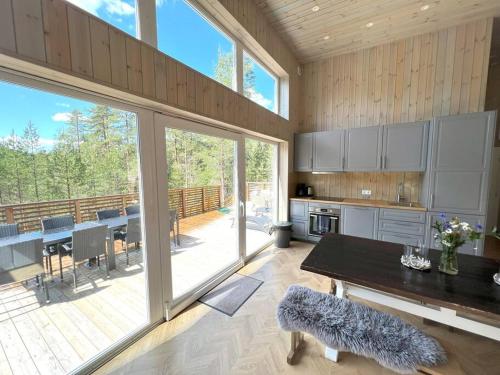 a large kitchen with a table and a large window at Tretoppen - Ny moderne hytte, Unike Finnskogen in Torsby