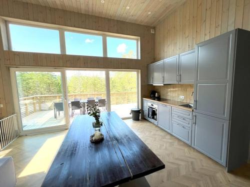 a kitchen with a wooden table and a large window at Tretoppen - Ny moderne hytte, Unike Finnskogen in Torsby