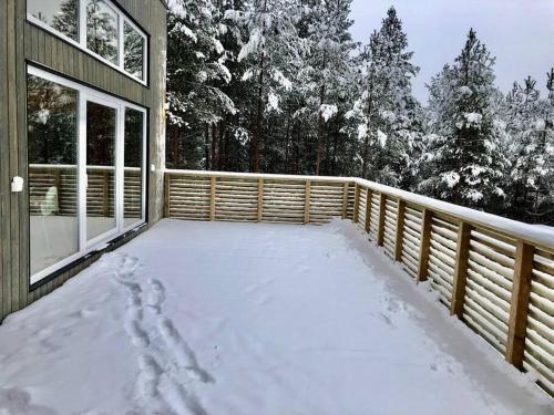 a porch covered in snow next to a house at Tretoppen - Ny moderne hytte, Unike Finnskogen in Torsby
