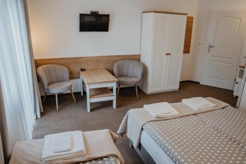 a room with two beds and a table and chairs at Willa U Jerzego in Karpacz