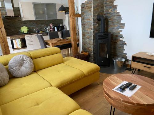 a yellow couch in a living room with a fireplace at Stadthaus Artur - Apartment Valencia in Remscheid
